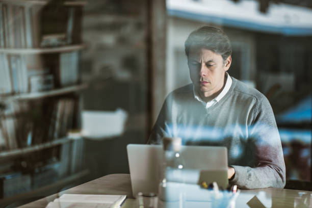 istock Mid adult entrepreneur working on a computer at home office. 1323463667