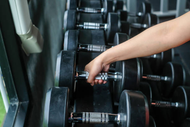 istock Strong well built bodybuilder lifting dumbbell weights getting ready for exercise in fitness 1323465305