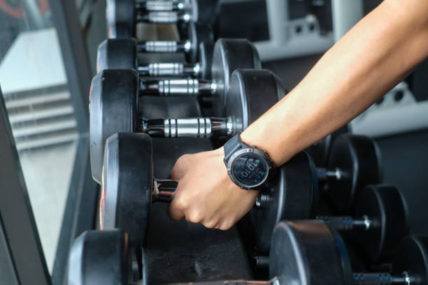 istock Strong well built bodybuilder lifting dumbbell weights getting ready for exercise in fitness 1323465307