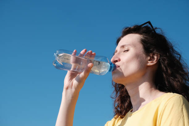 istock Girl drinks water from a bottle in hot weather 1323466768