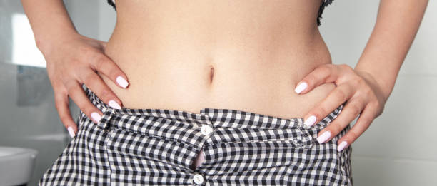 istock Young woman showing her belly. 1323468190