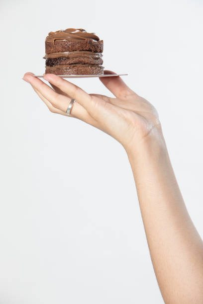 istock Woman hand holding chocolate cupcake 1323470540