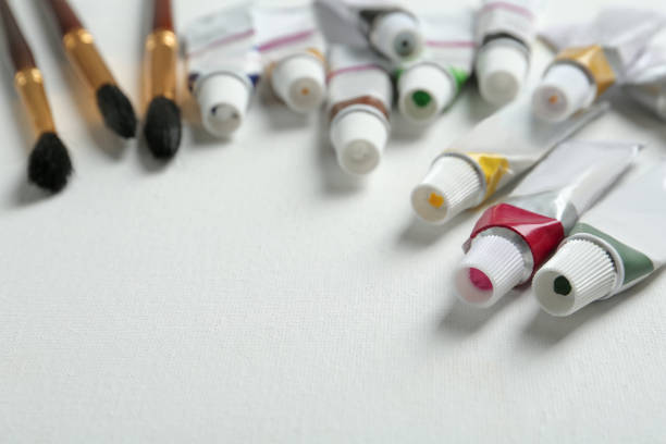 istock Brushes and paints on blank canvas, closeup. Space for text 1323472804