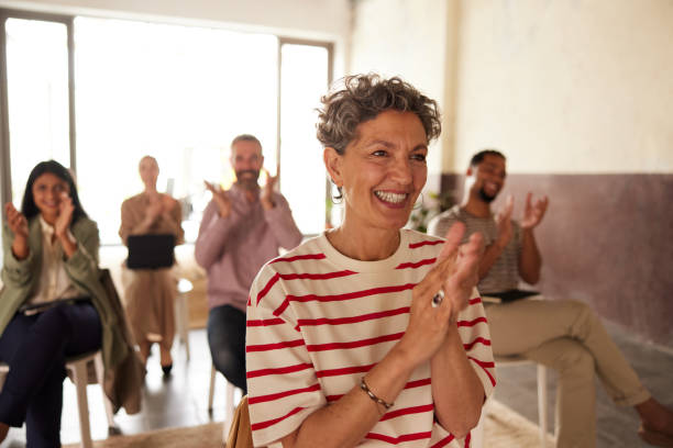 istock A woman in the audience clapping after a presentation. 1323473156
