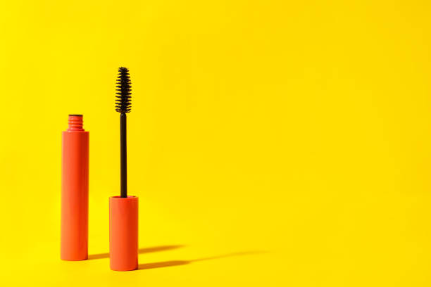 istock Mascara on yellow background, space for text. Makeup product 1323473249
