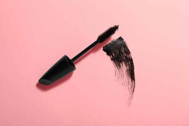 Mascara wand and smear on pink background, top view. Makeup product Mascara wand and smear on pink background, top view. Makeup product mascara stock pictures, royalty-free photos & images
