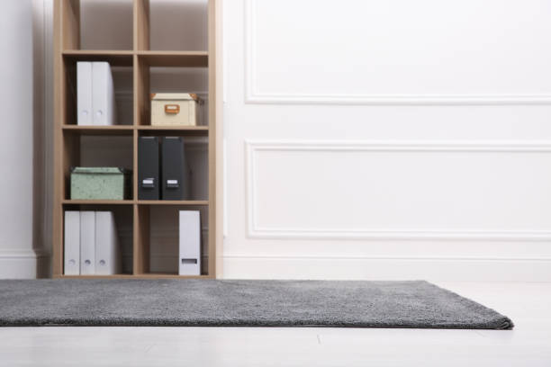 istock Room with soft grey carpet, shelving rack and white wall. Space for text 1323473521