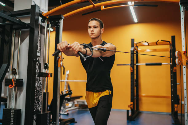 istock Handsome man doing triceps exercise with pulley in gym 1323473663