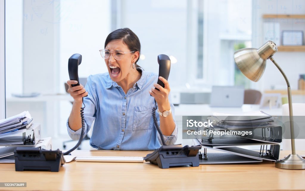 Shot of a young businesswoman screaming in frustration at her telephone So stressed I could scream Anger Stock Photo