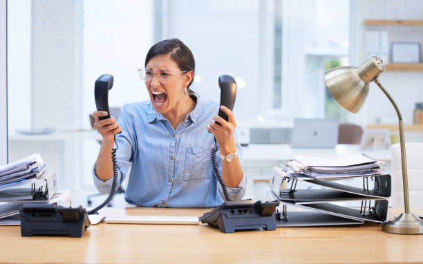 tiro de uma jovem empresária gritando de frustração em seu telefone - businesswoman frustration rudeness business - fotografias e filmes do acervo