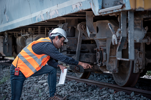 engineer under inspection and checking construction process railway and checking work on railroad station .Engineer wearing safety uniform and safety helmet in work.