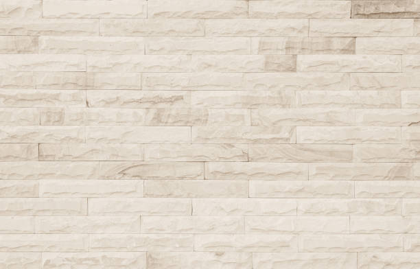 istock Empty Background of wide cream brick wall texture. Old brown brick wall concrete or stone pattern nature, wallpaper limestone abstract floor/Grid uneven interior rock. Home & office design backdrop. 1323479977