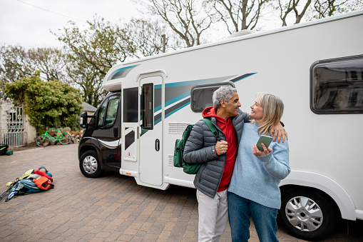 Couple standing together in front of their motor home in the North East of England. They are going on a road trip/staycation.