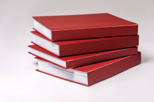 istock Stack of red hardcover books or reports on white background. 1323481011