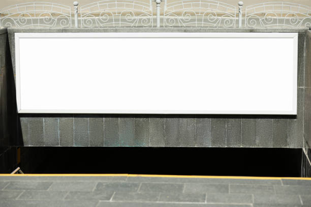 istock Blank advertising board hanging on wall near underground passage 1323483839