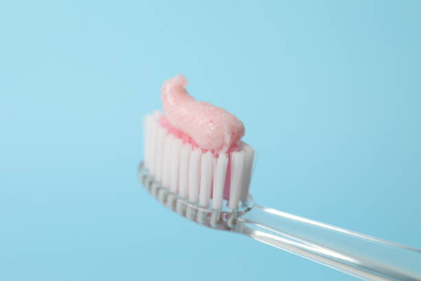 spazzolare con dentifricio su sfondo turchese, primo piano - toothbrush pink turquoise blue foto e immagini stock