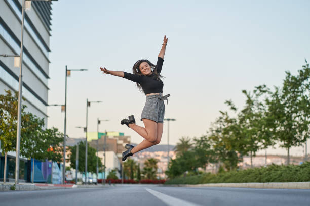 Young woman jumping for joy in the city stock photo