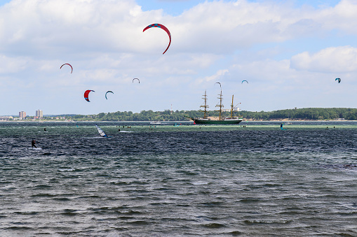 Lots of kite surfing activity at the Baltic Sea beach of Laboe in Germany on a sunny day.