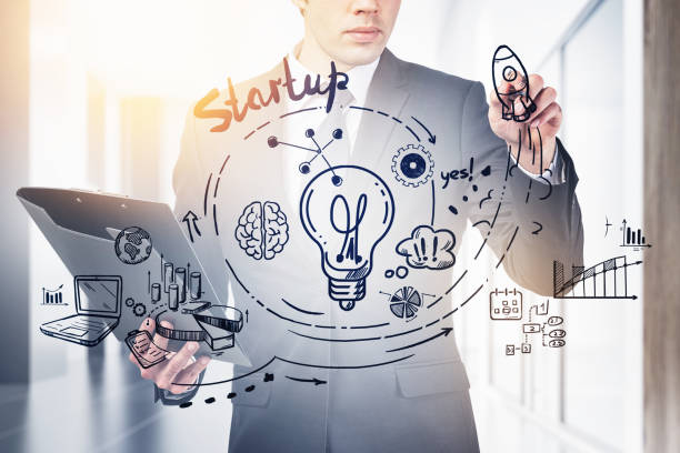 istock Businessman with pen and clipboard, start up sketch with light bulb 1323486359