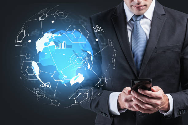 istock Businessman in suit checking smartphone. Abstract hologram plane 1323486747