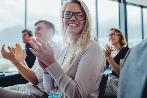 istock Businesspeople sitting at seminar clapping hands 1323487069