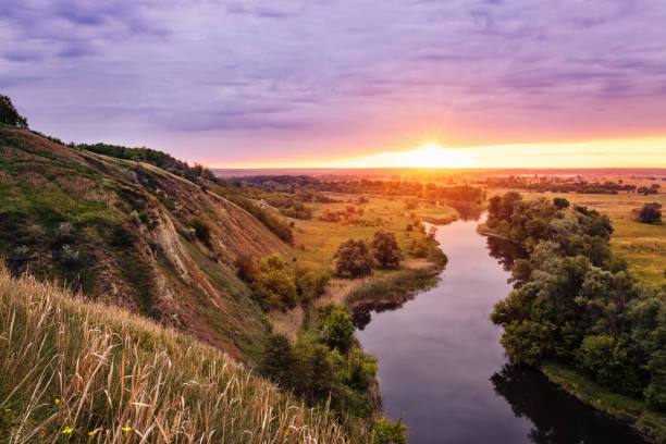 istock beautiful summer landscape sunrise over river with green meadow 1323488070