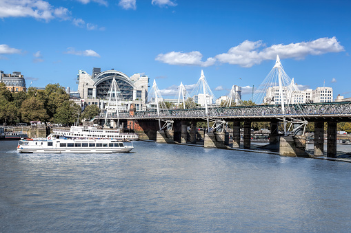 Golden Jubilee Bridge with tourist boats in London, England, UK