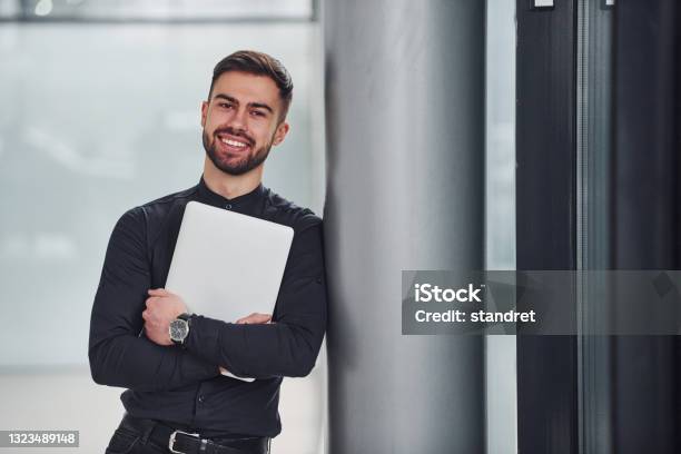 Junge Bärtige Kerl In Eleganten Kleidern Stehen Drinnen Vor Grauem Hintergrund Stockfoto und mehr Bilder von Unternehmer