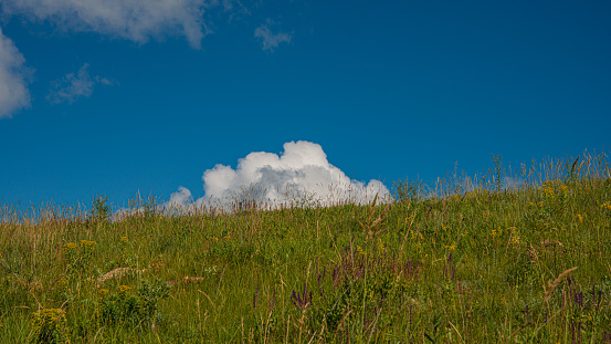 white cloud on top of the hill and blue sky, sunny day. Spring season. Web banner. Natural background for design. Ukraine. Europe.