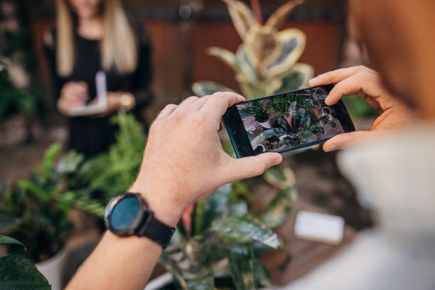 istock Man taking pictures of plants 1323494143