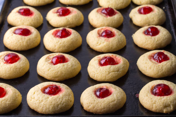 istock Cherry cookies on baking tray - delicious cherry topped cookies 1323495254