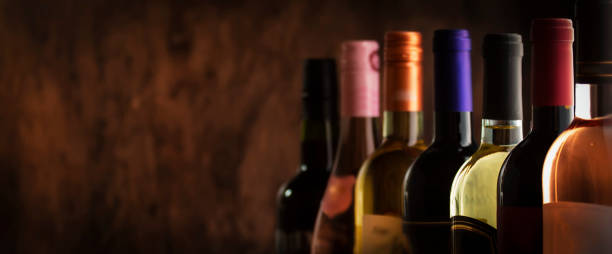fila di raccolta bottiglie di vino in cantina, cantina seminterrato, bar o negozio su sfondo di legno scuro - bottiglia di vino foto e immagini stock