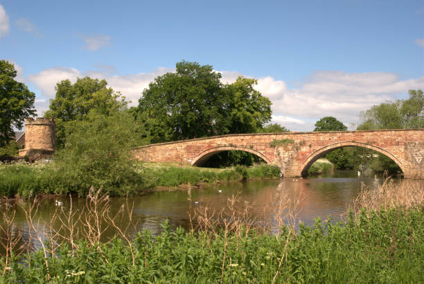 historic arched stone bridge and tower bridge on Tyne in Haddington in summer