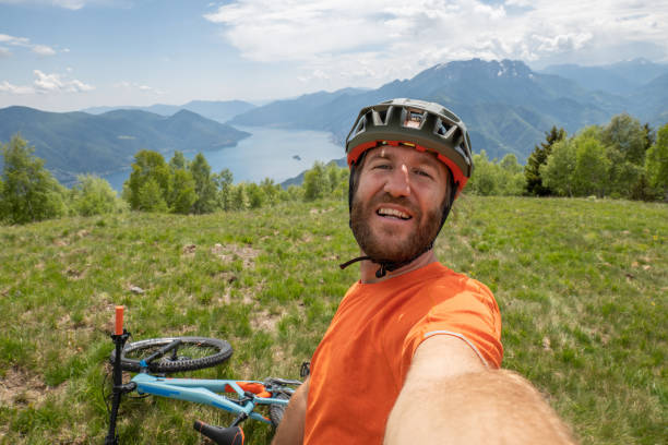 istock Young man mountain biker takes selfie on mountain top 1323499526