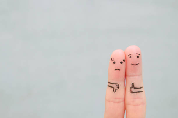 Fingers art of couple. Woman showing thumb down and man showing thumb up. Concept of disagreement in family. Fingers art of couple. Woman showing thumb down and man showing thumb up. Concept of disagreement in family. pessimism photos stock pictures, royalty-free photos & images
