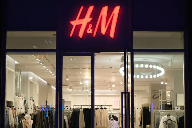 Facade of H&M clothing store at night. Shanghai.China-June 2021: Facade of HM clothing store at night. Red logo on entrance. A Swedish fashion brand h and m stock pictures, royalty-free photos & images