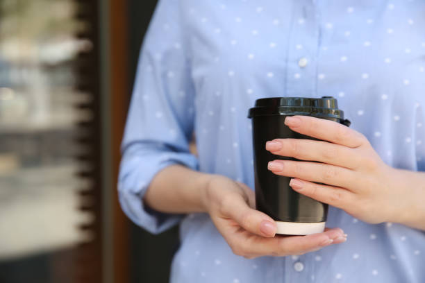 istock Woman with takeaway coffee cup outdoors, closeup 1323501925