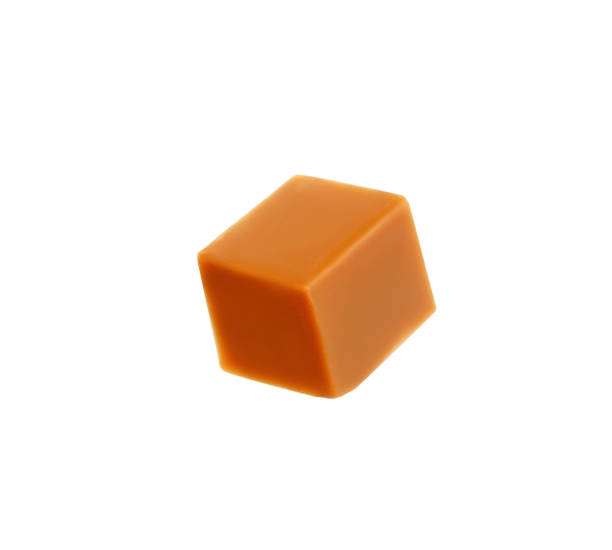 istock One caramel cube isolated on white. Confectionery 1323502570