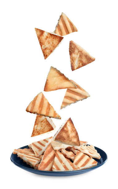 Delicious crispy pita chips falling into plate on white background Delicious crispy pita chips falling into plate on white background pita bread stock pictures, royalty-free photos & images