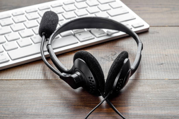 istock Office desk with headset and pc call center support 1323508112