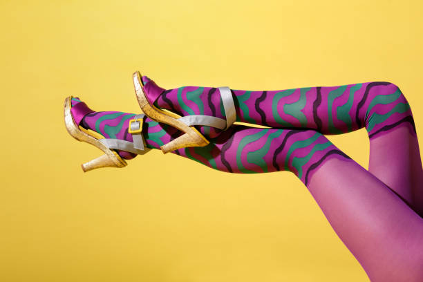 istock Sexy shapely female legs in multicoloured purple collant 1323508757