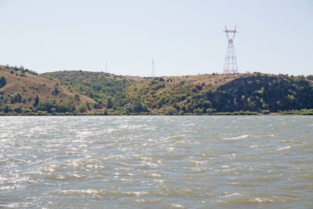 istock Danube river, water surface on a summer sunny day. Hills in the background with electricity towers. 1323508919