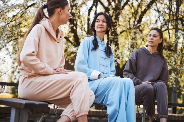 istock Tai chi instructor sitting between two women 1323510097