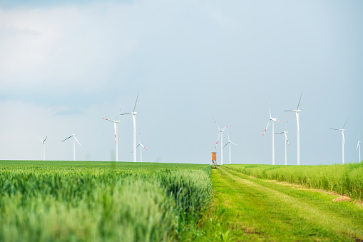 Germany: Different colourful fields with wind trubines in spring on a rainy day.