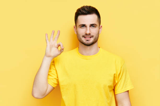 istock Smiling handsome man doing ok sign with hand and fingers 1323511559