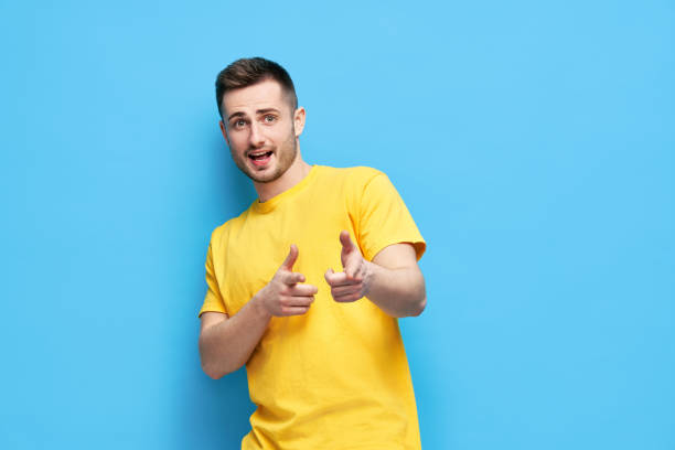 istock Funny joyful man pointing at you and looking to camera on blue background 1323511564
