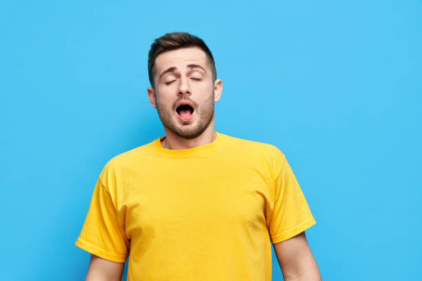 istock Yawning or sneezing young man over background 1323511568