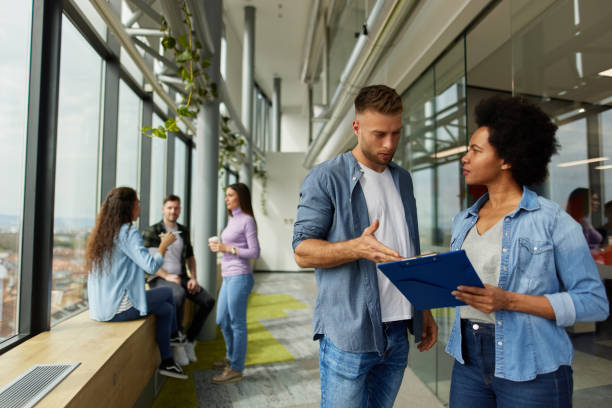 istock Two business people discussing document in office hallway 1323512623