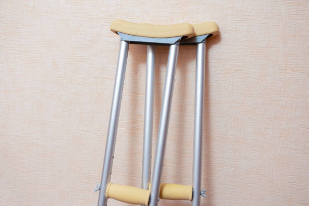 conceptos médicos. par de muletas para personas discapacitadas colocadas contra la pared en interiores.orientación horizontal - crutch fotografías e imágenes de stock