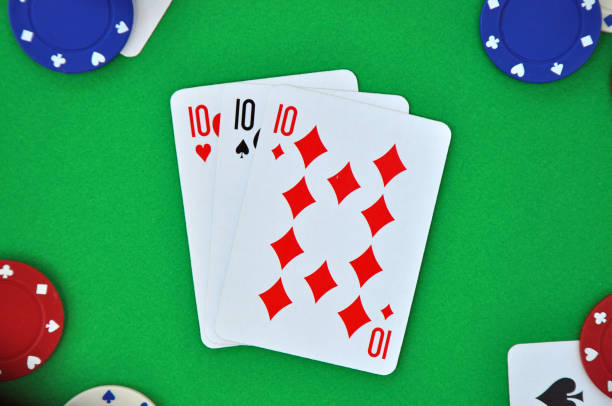 istock Three of a kind (tens). Playing cards. Poker hand or suit on green baize 1323512819